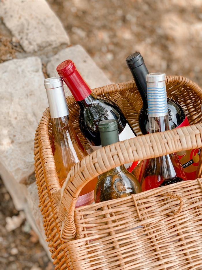 Picnic basket filled with wine bottles in Napa, CA setting. Ideal for outdoor occasions.